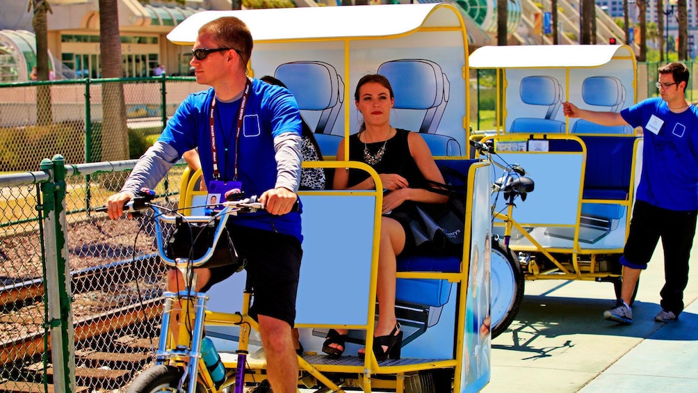 woman riding a taxi bike along train tracks in San Diego