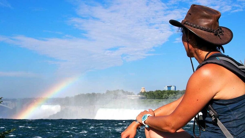 woman looking at a rainbow by the waterfall at Niagara Falls