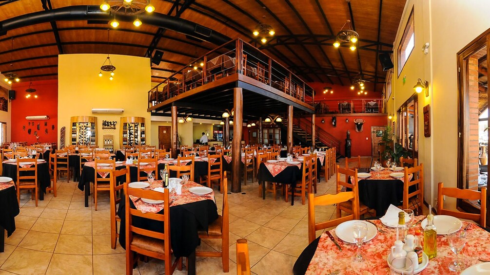 Carregar foto 4 de 10. Interior view of empty restaurant with prepared dinner tables.