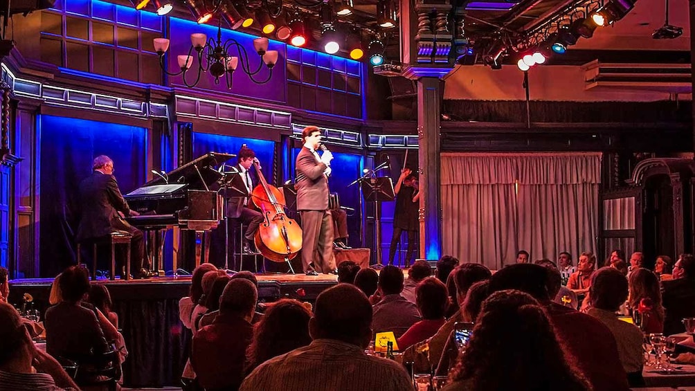 Cargar ítem 1 de 10. Instrumentalists performing on stage to an audience.