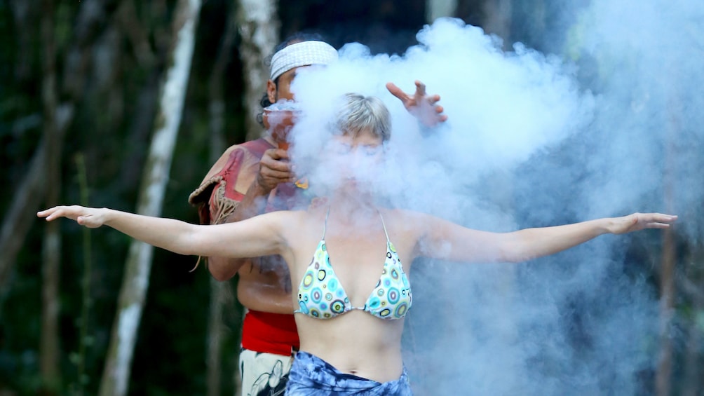 Shaman performing purification smoke ritual on a woman in Cancun