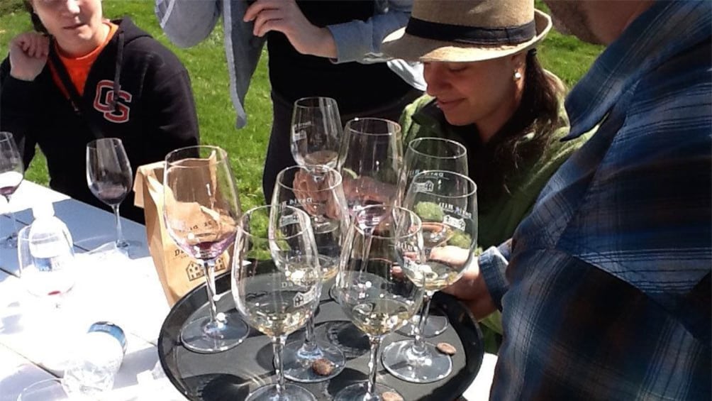 Group with a tray of wine glasses outside a winery in Portland
