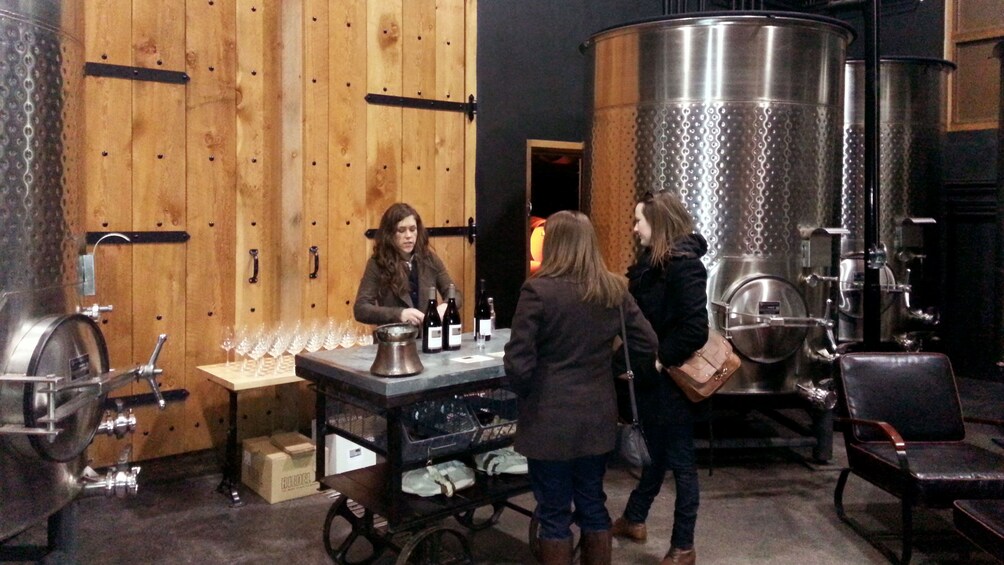Show item 5 of 10. Women with sommelier pouring wine inside a winery in Portland