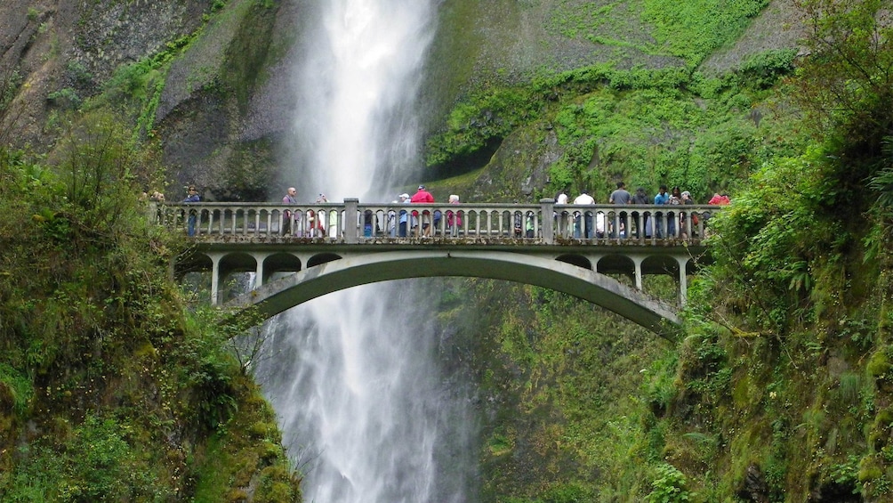 Tourists on the bridge overlooking the Multnomah Falls in Portland 