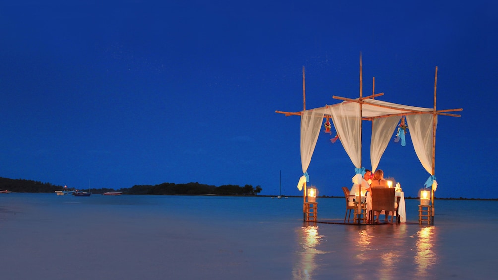 Couple dining on the beach by candlelight in Koh Samui