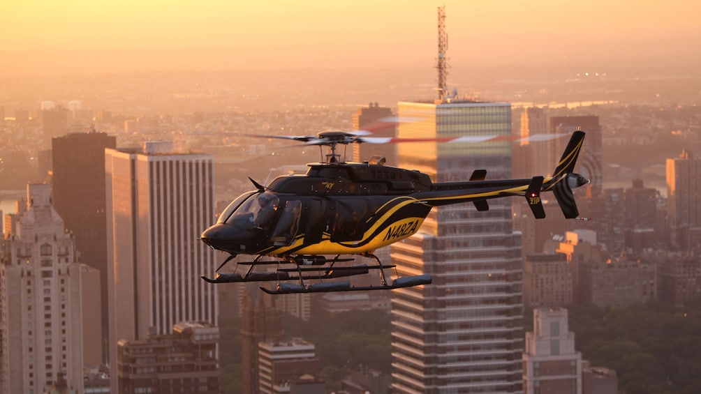 A Helicopter flying above the New York skyline at dusk