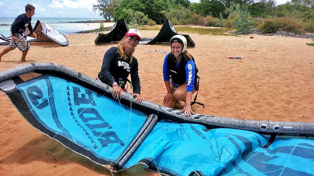 Show item 1 of 8. setting up the kiteboard with instructor in Maui