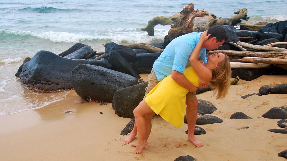 Couple kissing on beach in Kauai