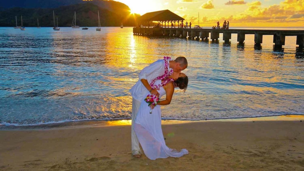 Man and woman kissing at sunset in Kauai