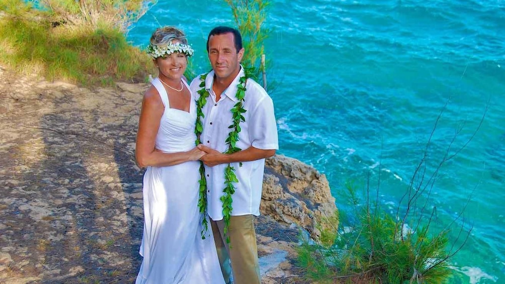Couple standing at water's edge in Kauai