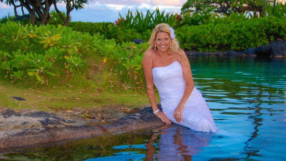 woman sitting on edge of water in Kauai