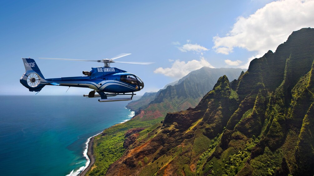 helicopter flying over mountain ridges in Kauai