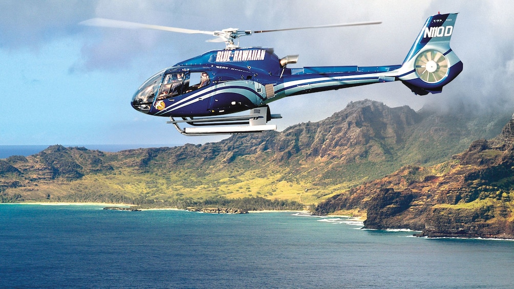 helicopter flying over ocean shores in Kauai