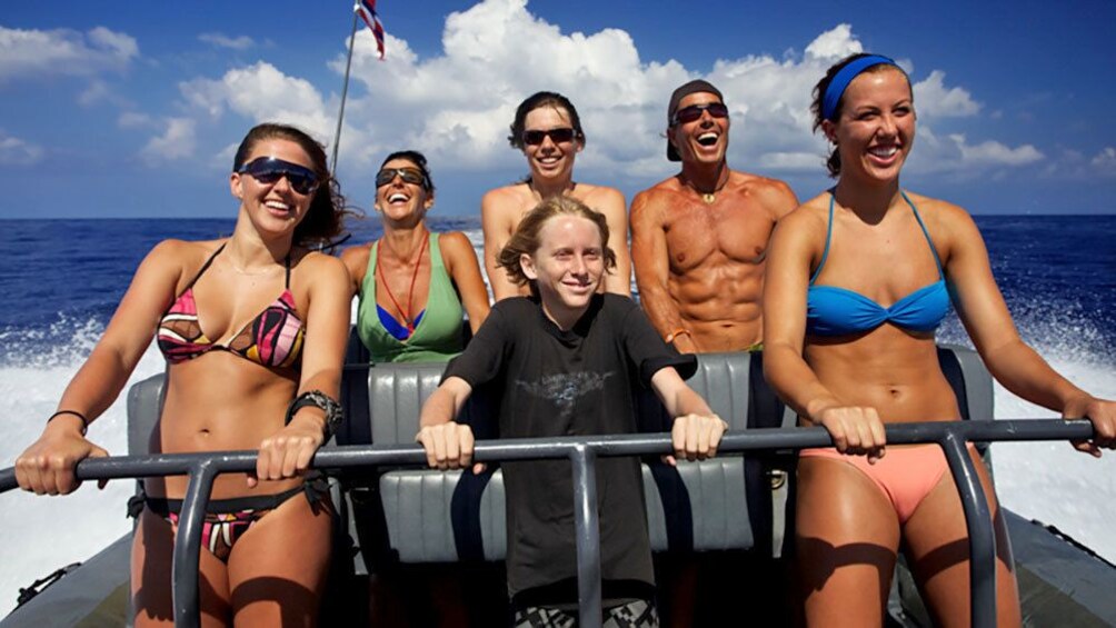 speeding motorboat passengers hanging on to the rails in Hawaii
