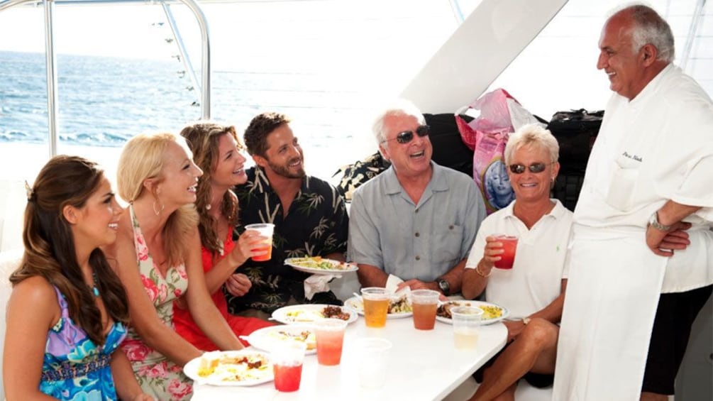 Show item 3 of 5. Dining group being greeted by a chef on a boat on Maui