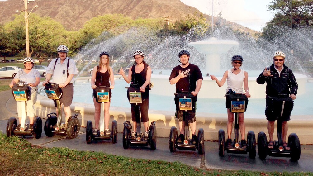 Tourists on Segway stop to enjoy views of a spectacular water feature in Honolulu