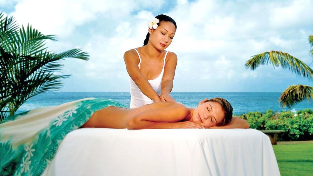 woman enjoying a back massage at the beach in Kauai