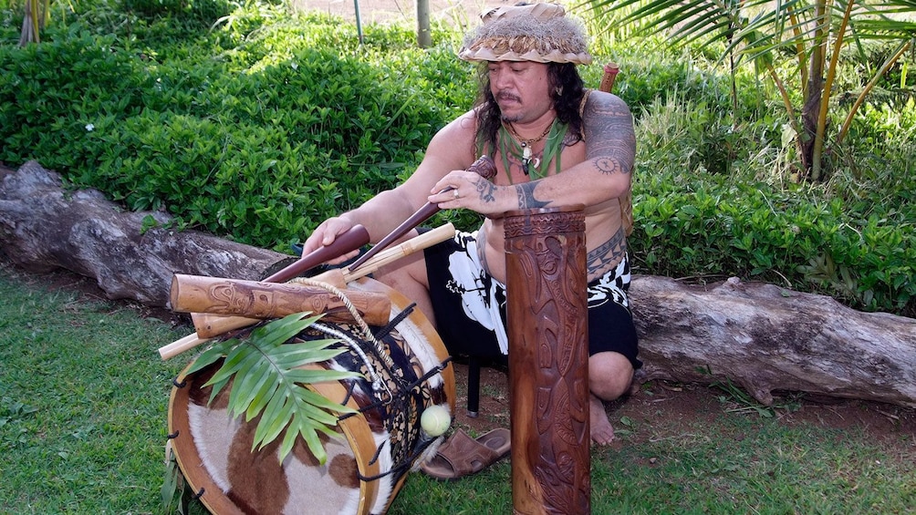 man playing drums and pipes at  luau in Kauai