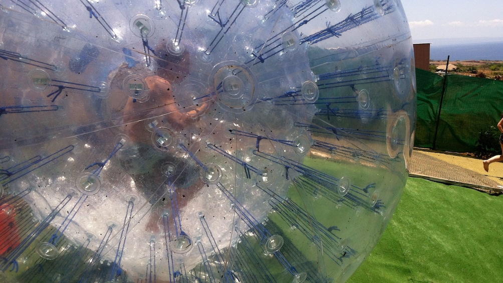 man in aquaball running through a course in Maui