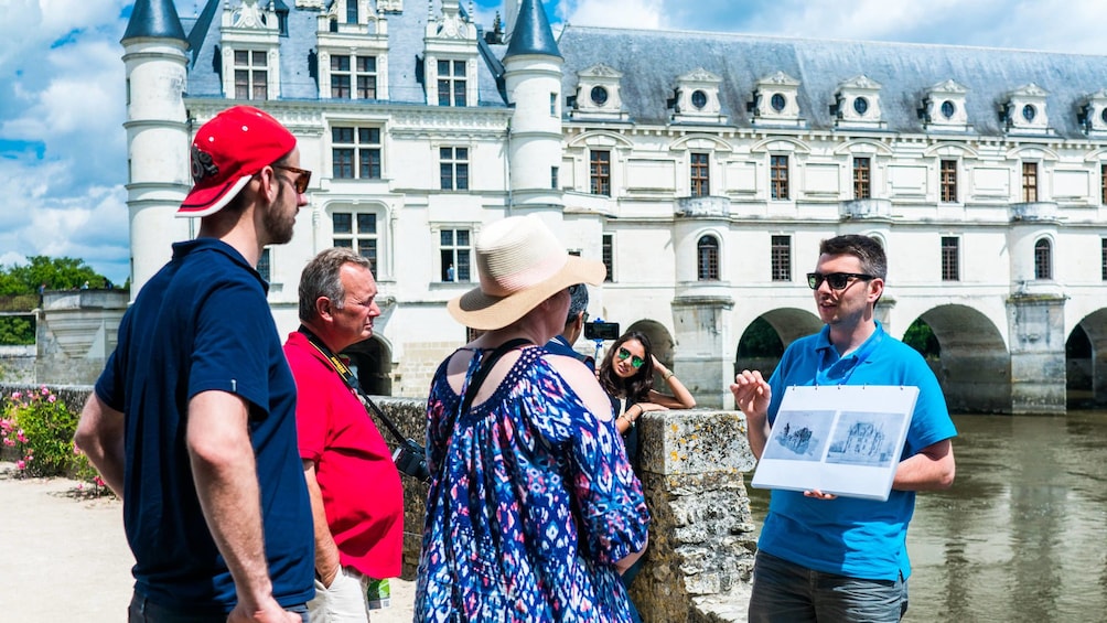 Guide with tour group outside Chenonceau castle 