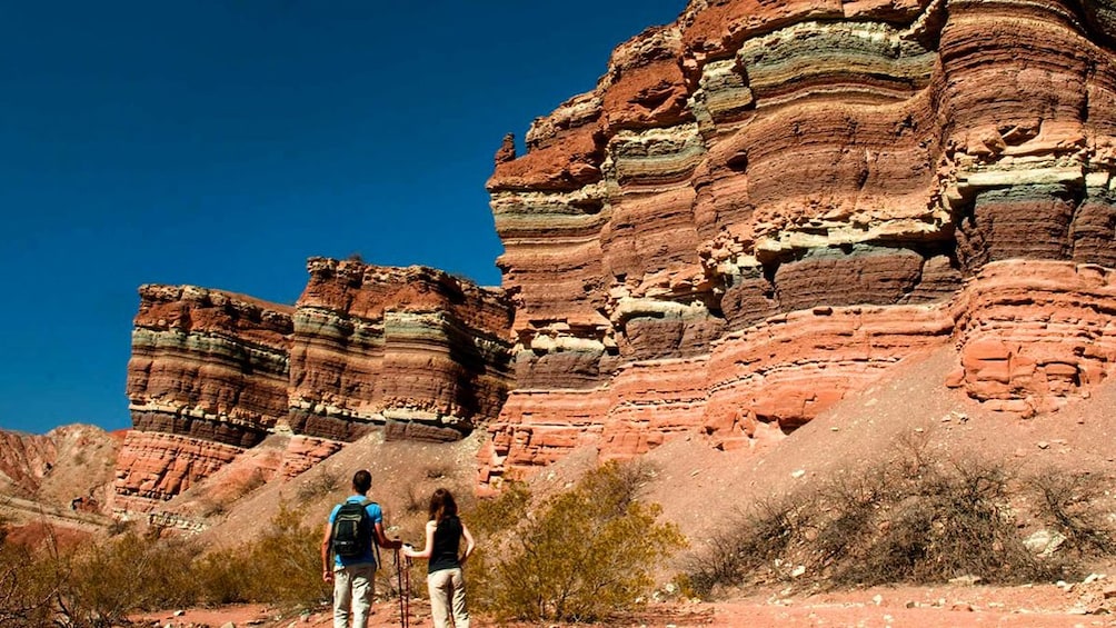 Two hikers observing beautiful layered canyons.