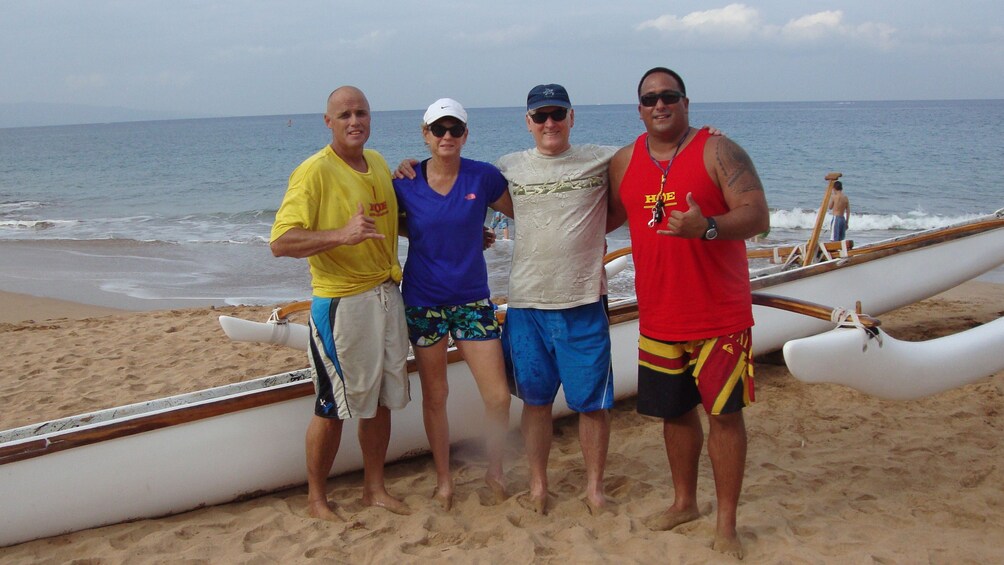 Four men on the beach in Maui next to an Outrigger Canoe