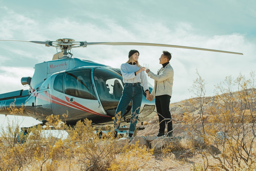 Couple toast in front of helicopter at Red Rock Canyon Landing 