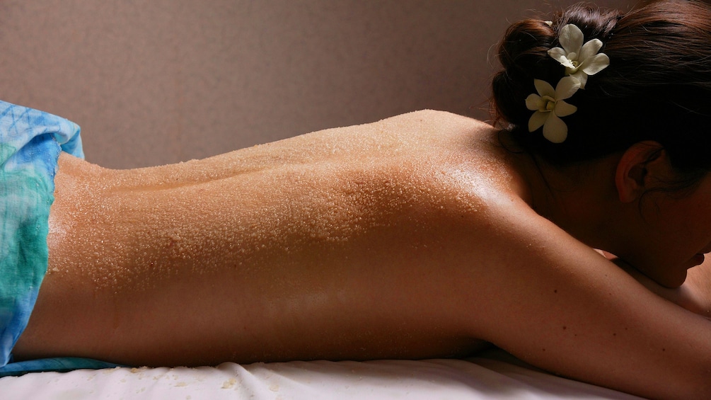 Topless woman lays on a table in a spa