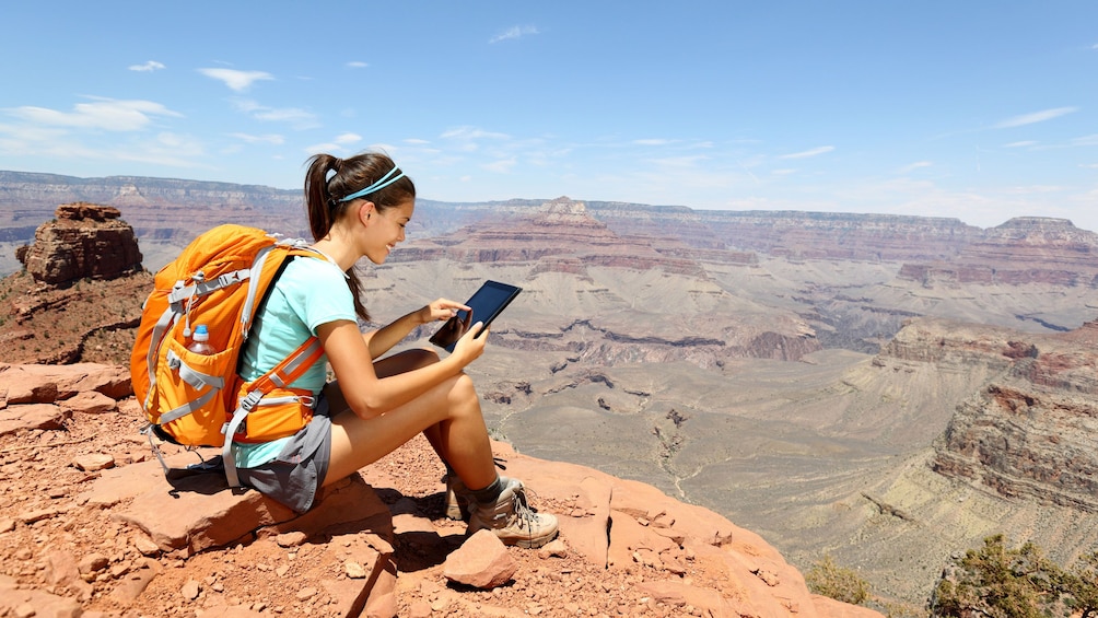 Woman capturing a memorable photo during her tour of the Grand Canyon