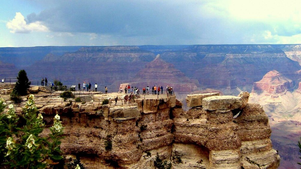 Visitors to the Grand Canyon stand on a scenic vista