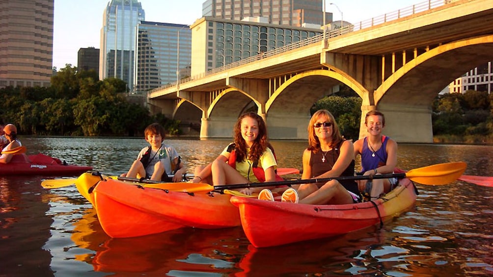 Group of kayakers paddling across river.