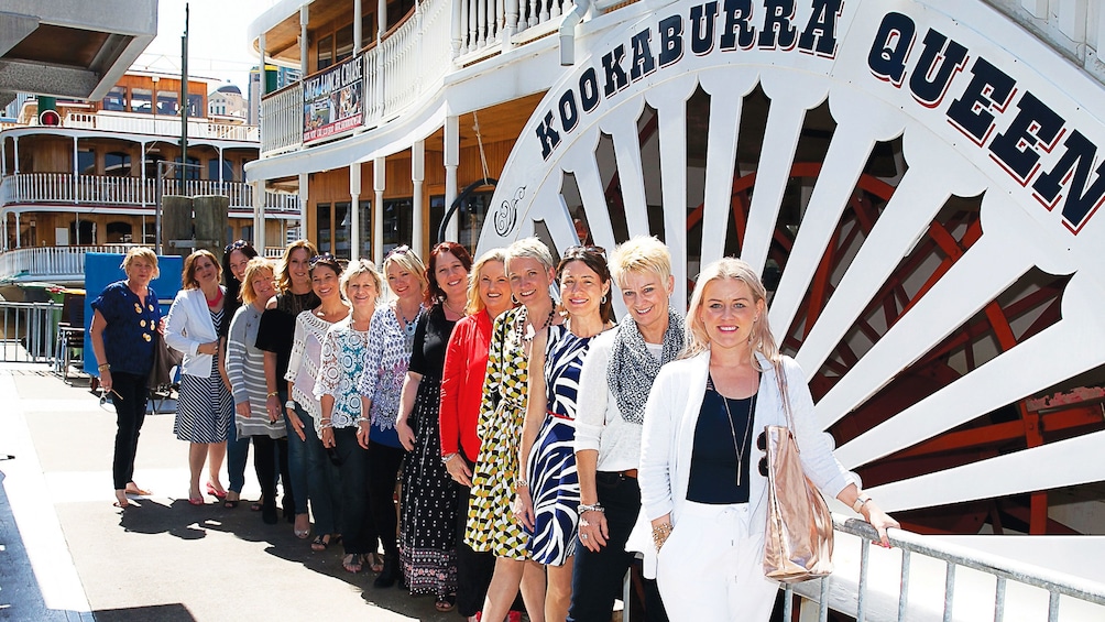 Group stand next to cruise boat in Brisbane