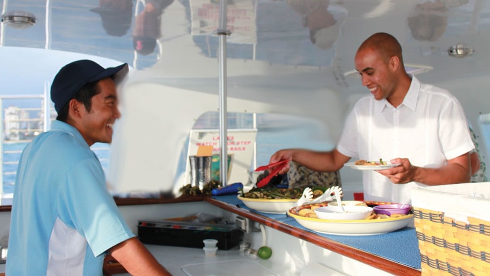 Guests preparing food aboard a sunset cruise in Oahu Hawaii 