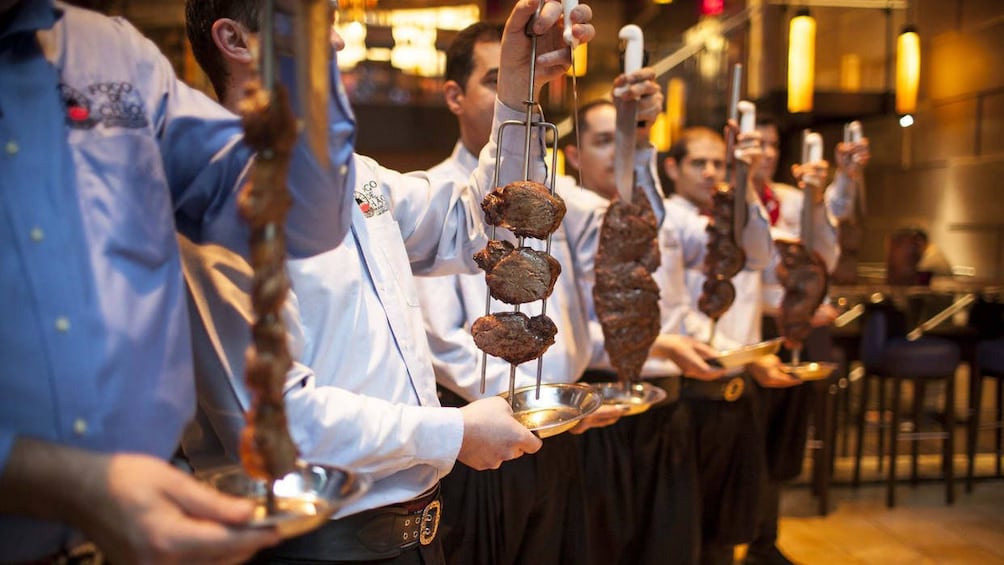 Row of servers with meat at a Brazilian restaurant in Rio de Janeiro