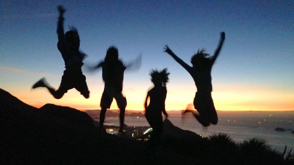 Group of people jumping at Sunset over Rio De Janeiro 