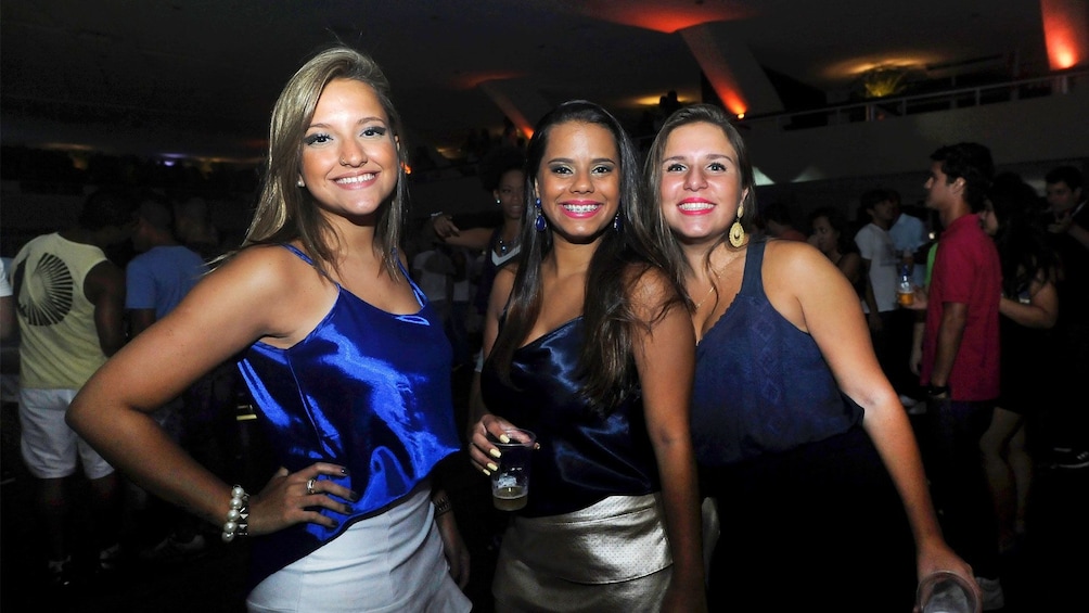 Three girls pose of photo at nightclub in Rio de Janeiro
