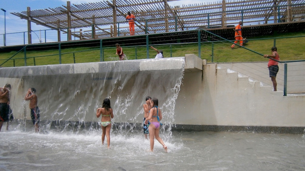 People wading and playing in a waterfall at Madureira Park in Rio de Janeiro