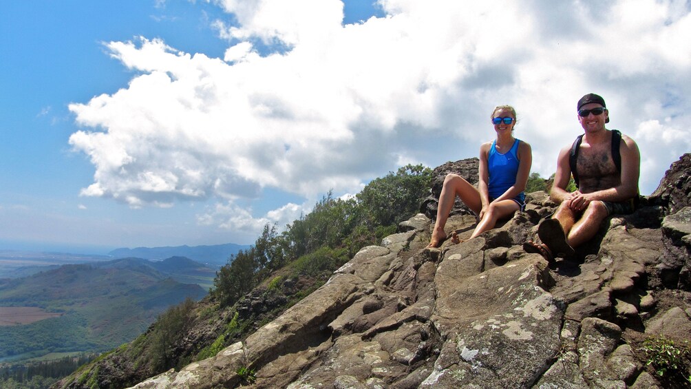 Couple sitting at the top of Nounou Mountain on Kauai