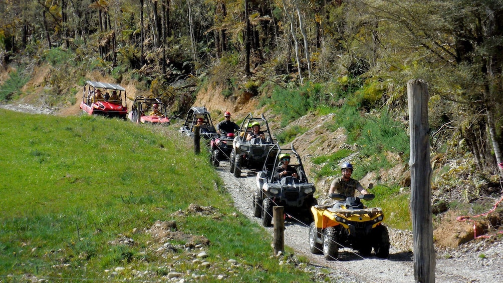 Line of ATVs and buggies on a dirt road in New Zealand