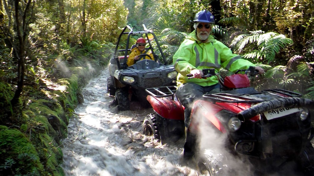 ATV and dune buggy splashing through a river in New Zealand