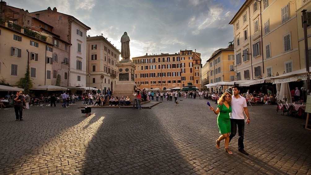 Couple walking across a piazza in Rome