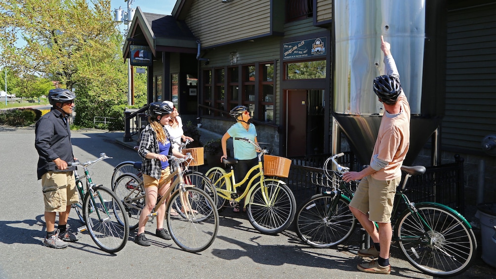 Show item 1 of 5. Bicycling group with tour guide outside a brewery in Victoria