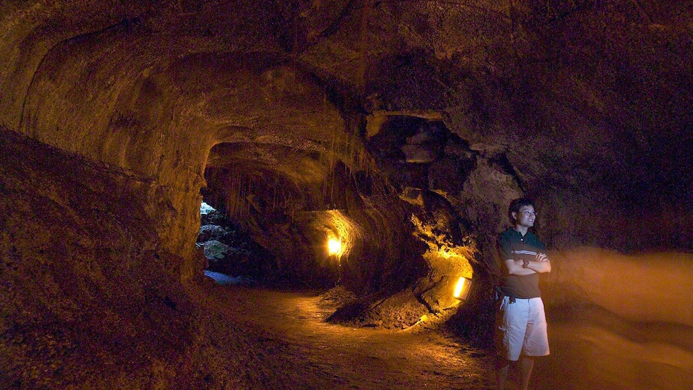 A man stands in a lava tube in Oahu