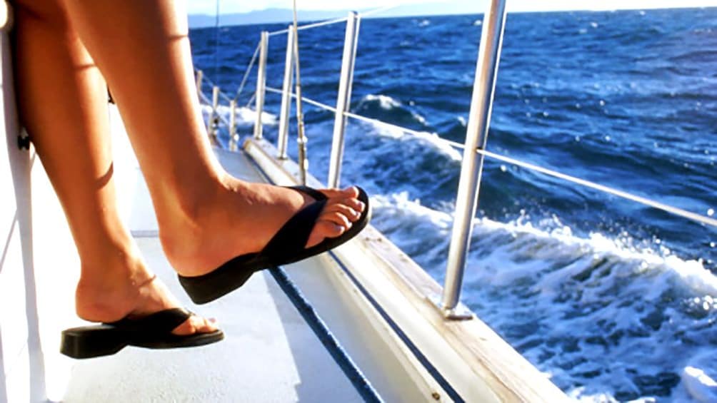 sitting on the side of a catamaran in Thailand