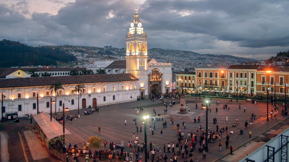 Plaza between historic buildings at night in Quito