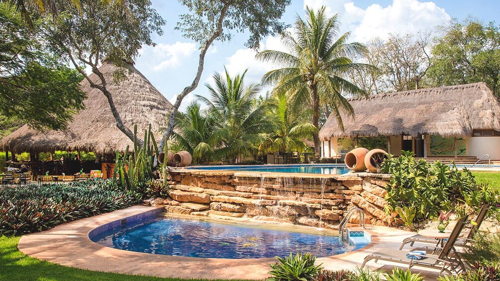 Exterior view of resort featuring beautifully manicured pool and lawn.