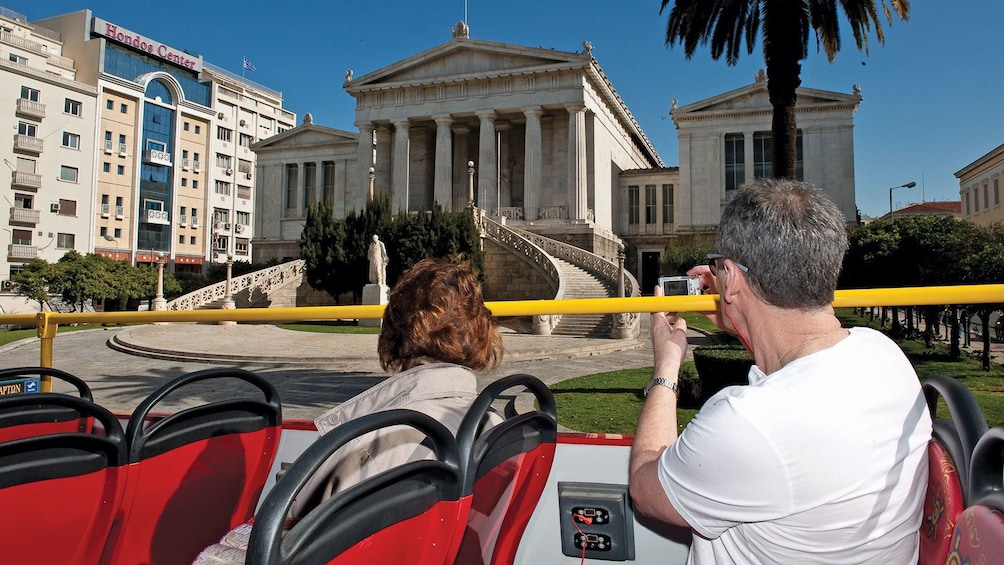 bus passengers taking pictures of historical buildings in Athens