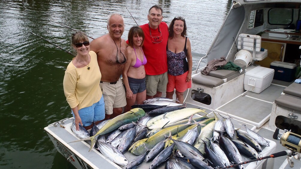 five people show off there large catch on fishing boat in Kauai