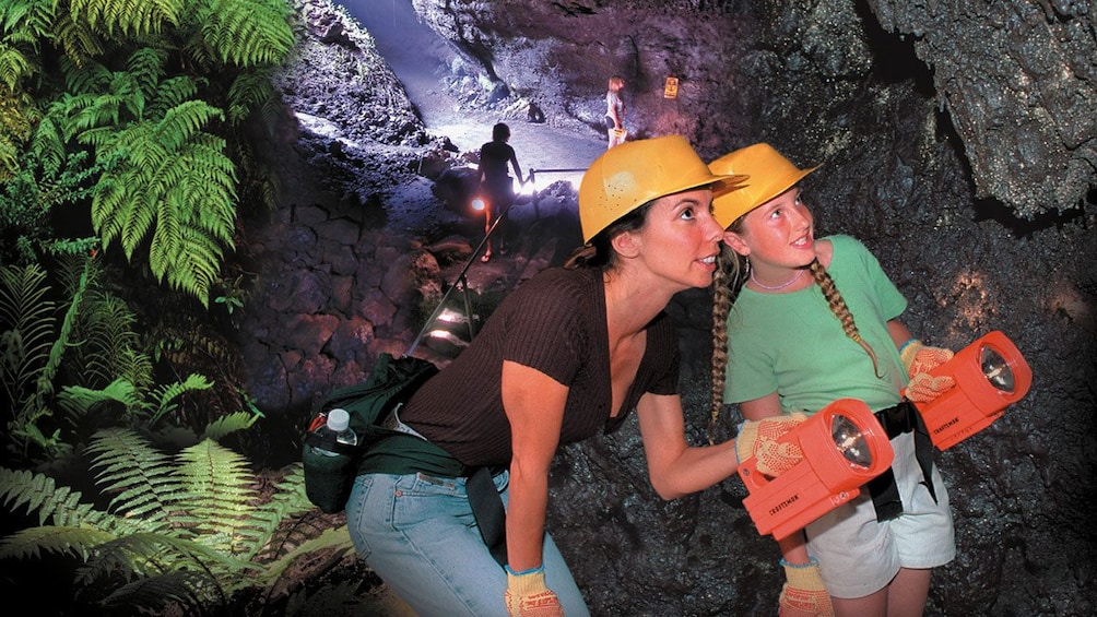 Mother and daughter with flash lights in cave in Maui 