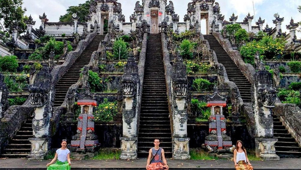 Show item 1 of 5. Three people meditating at a shrine in Samui City